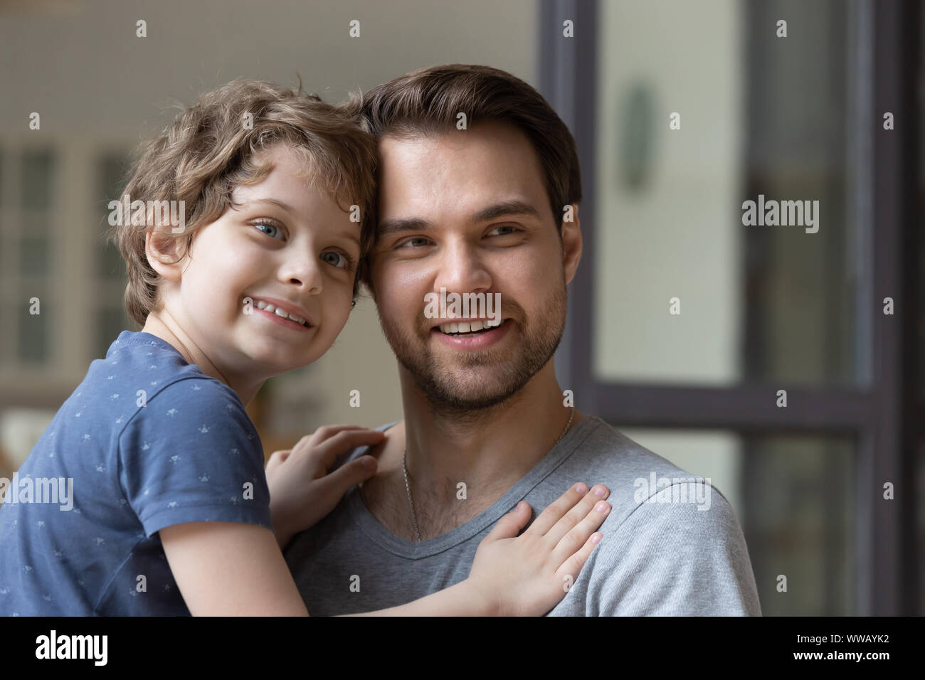 Young smiling father holding little preschool son on hands Stock Photo ...