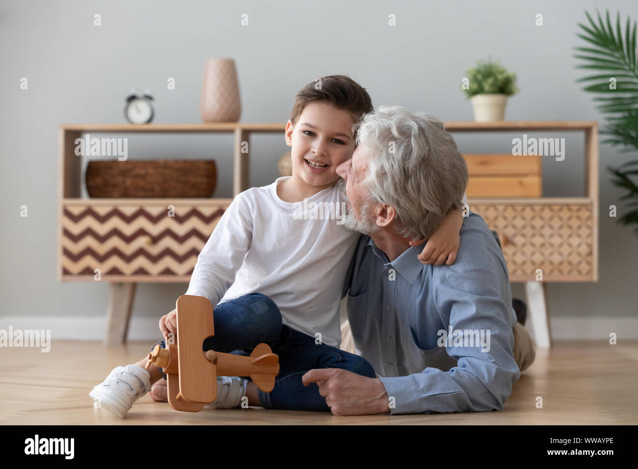 Happy old grandad embracing cute small grandson looking at camera Stock ...