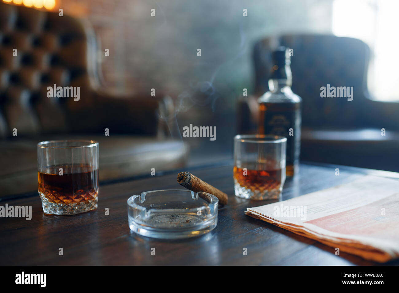 Whiskey and cigar on wooden table in retro office Stock Photo