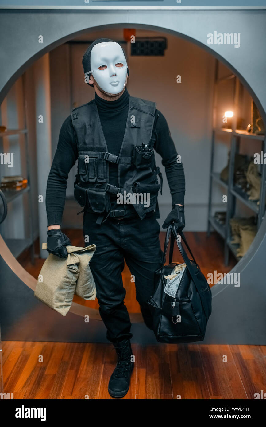 Bank robbery, robber in black uniform and mask Stock Photo