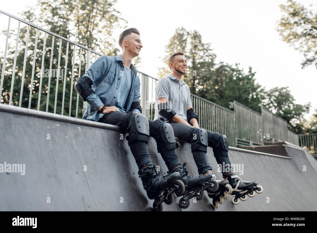 Roller skating, two skaters sitting on the ramp Stock Photo Alamy