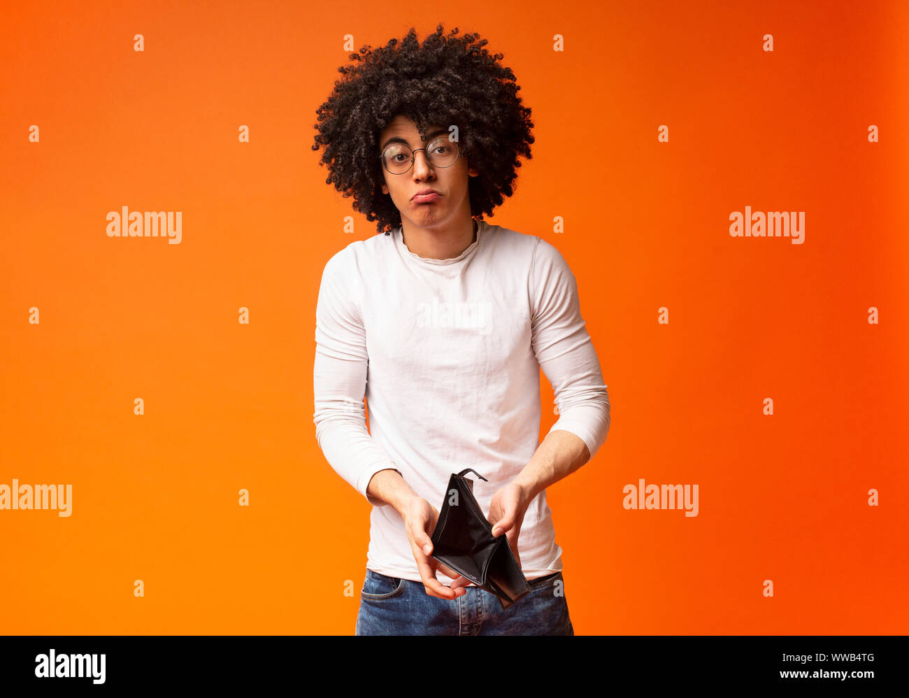 Unhappy Black Millennial Guy Showing Empty Wallet Stock Photo