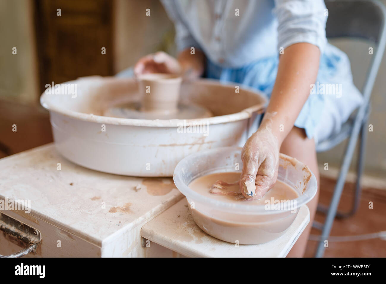 Female master making a pot on pottery wheel Stock Photo