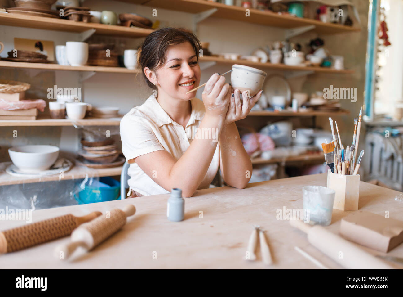 Female master paints a pot, pottery workshop Stock Photo - Alamy