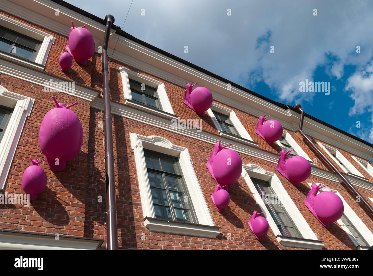 SAINT-PETERSBURG, RUSSIA – JULY 7, 2019: New Holland Island.The pink snails on the wall by Cracking Art Stock Photo