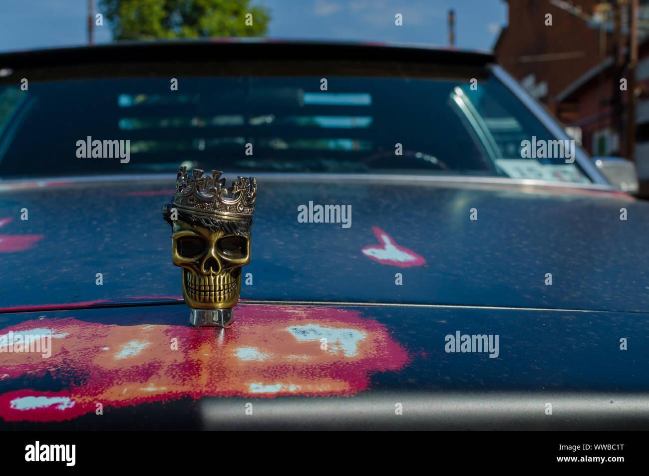 WROCLAW, POLAND - August 11, 2019: USA cars show - metallic skull with a crown on the hood of the car Cadillac DeVille. Close-up. Stock Photo