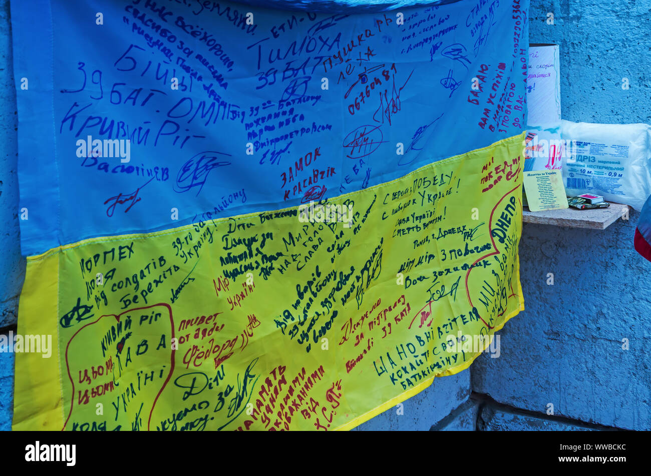 Dnipro, Ukraine - May 25, 2016: Ukrainian flag with signatures of soldiers located in exact copy of a military  in museum of the Russian-Ukrainian war Stock Photo