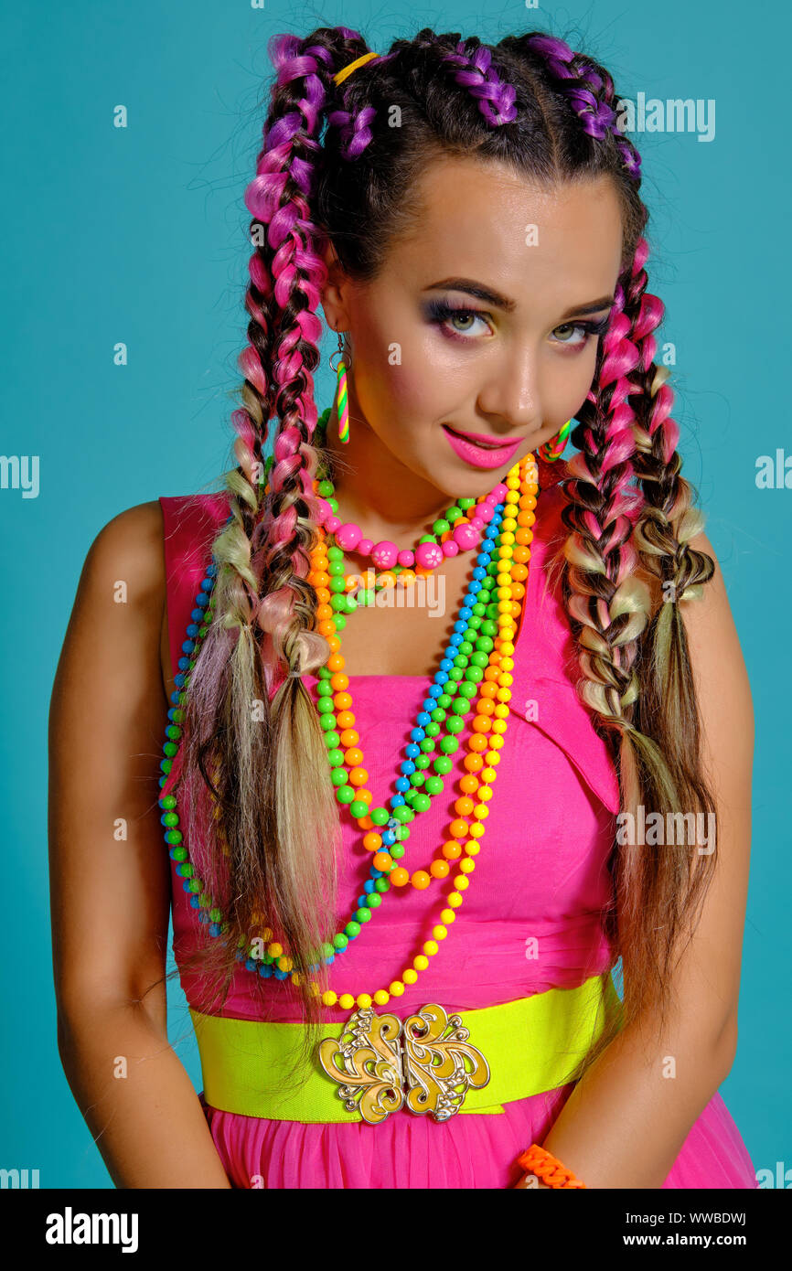Lovely girl with a multicolored braids hairstyle and bright makeup