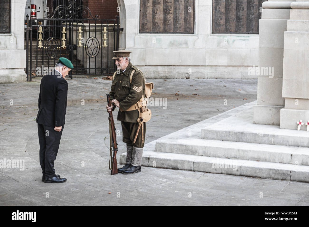 A man in British world war one soldiers uniform handing over a vigil to a modern day war veteran Stock Photo