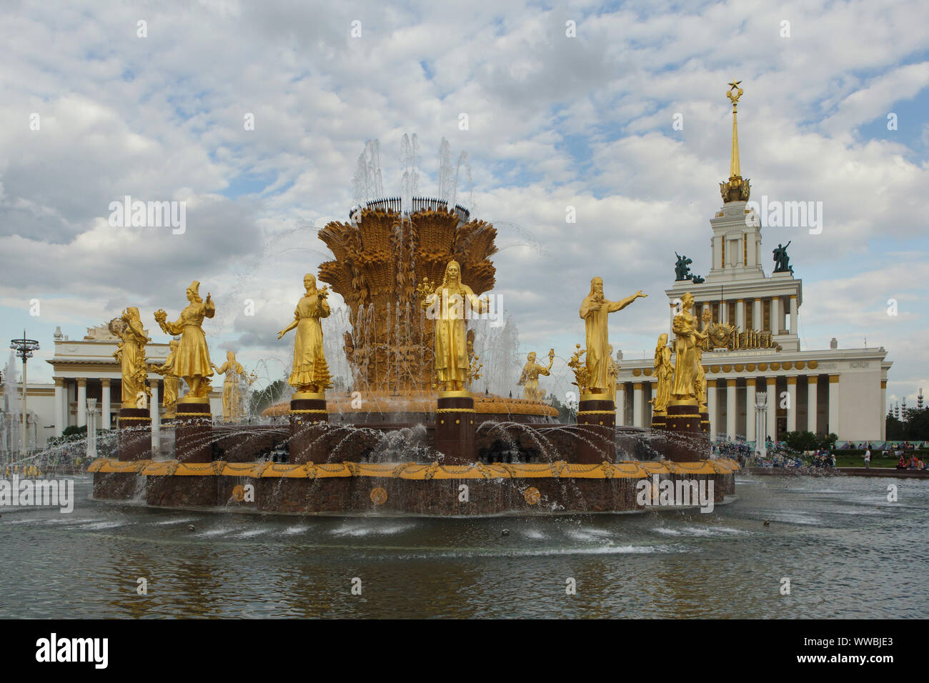 Friendship of Nations (Friendship of Peoples) Fountain on the main square in the VDNH exhibition ground (Exhibition of Achievements of National Economy) in Moscow, Russia. The fountain designed by Soviet architect Konstantin Topuridze decorated with sixteen gilded statues of the nations of the Soviet Union by Soviet sculptors Zinaida Bazehenova, Alexey Teneta, Iosif Chaykov, Zoya Ryleyeva and others was built in 1954. The fountain is also known as the Golden Sheaf. Stock Photo