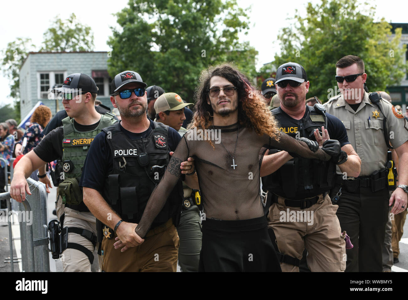 Dahlonega, Georgia, USA. 14th Sep, 2019. Police arrest a protester who tried to attack Chester Doles, a longtime white nationalist leader, as he led what he described as an 'American Patriot Rally'' to honor President Trump in Dahlonega, Georgia on Saturday. All told, around 50 people joined Doles' rally, while around 100 people joined counter-protests, including members of the so-called 'Anti-fascist'' movement. Hundreds of law enforcement officers from surrounding counties policed the event, easily outnumbering demonstrators as shops and cafes in the small North Georgia town shut Stock Photo