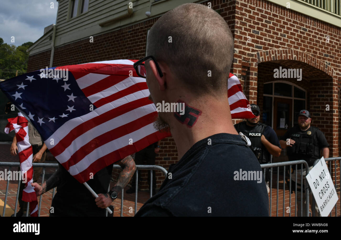Dahlonega, Georgia, USA. 14th Sep, 2019. Tennessee resident KYNAN DUTTON, who once moved to North Dakota to build an all-white enclave there, watches a rally organized by longtime white nationalist leader Chester Doles in Dahonega, Georgia on Saturday. Doles billed the event, which drew around 50 supporters, as an 'American Patriot Rally'' to honor President Trump. Around 100 counter-protesters including affiliates of the so-called 'Antifa'' movement showed up, as well as hundreds of law enforcement agents from surrounding counties as shops and restaurants in the small, north Georgia Stock Photo