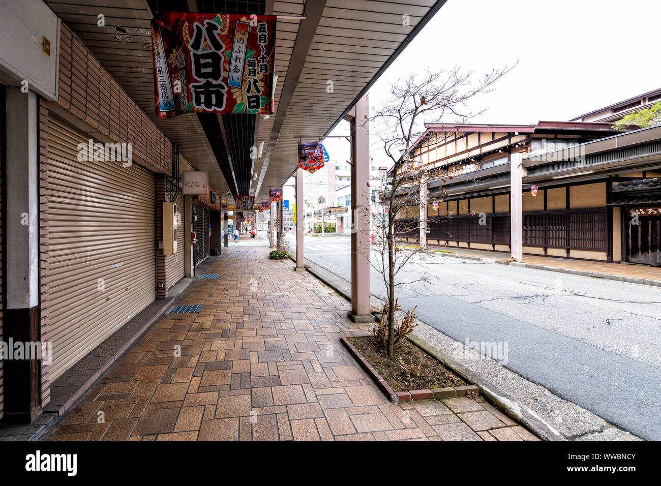 Takayama, Japan - April 7, 2019: Gifu prefecture city town with covered street road shopping arcade, hanging colorful signs in spring Stock Photo