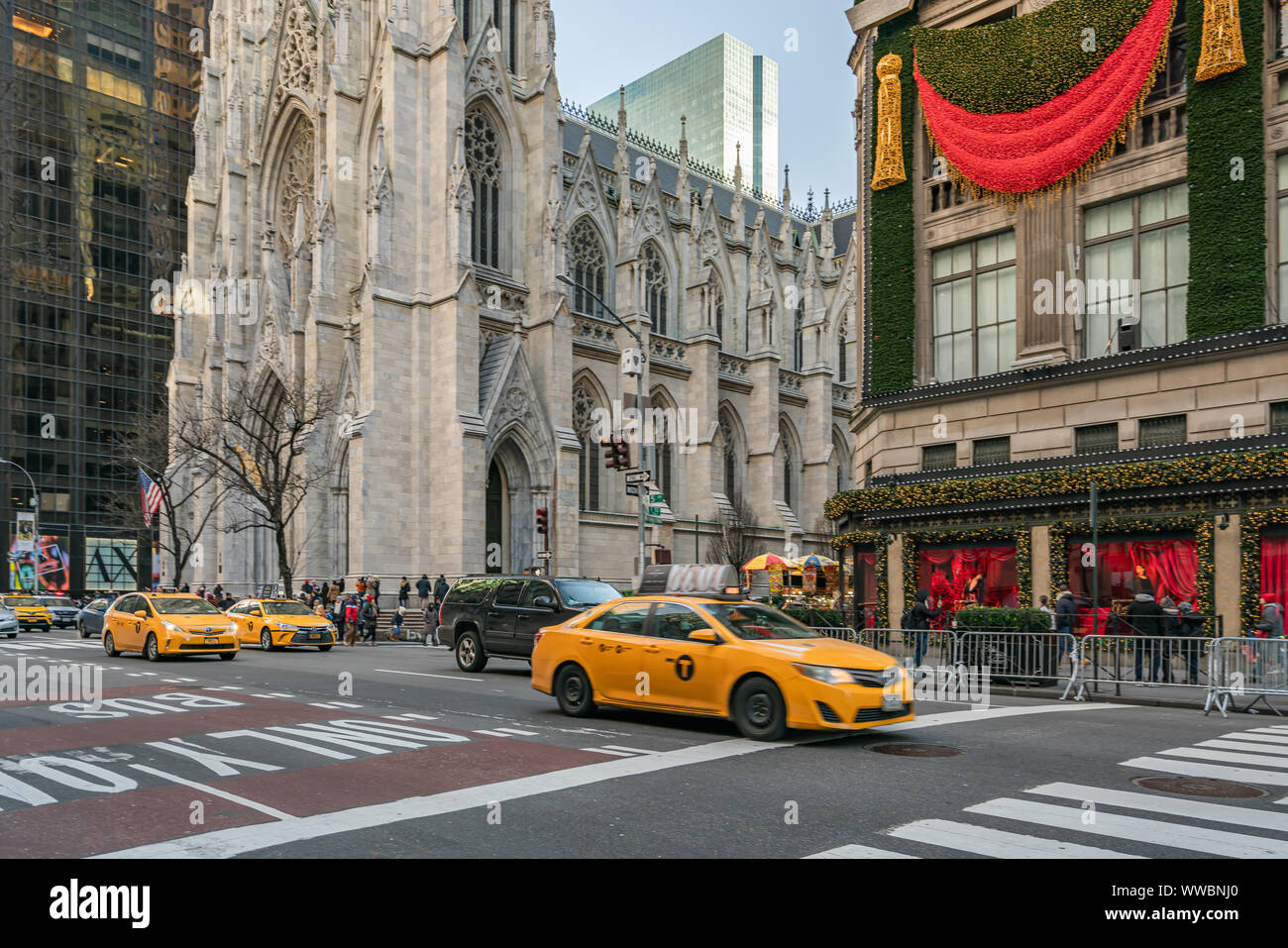 New York City, NY, USA - December, 2018 - Streets of Manhattan, Classic Yellow Taxi crossing the Fifth Avenue near Saks Fifth Avenue Stock Photo