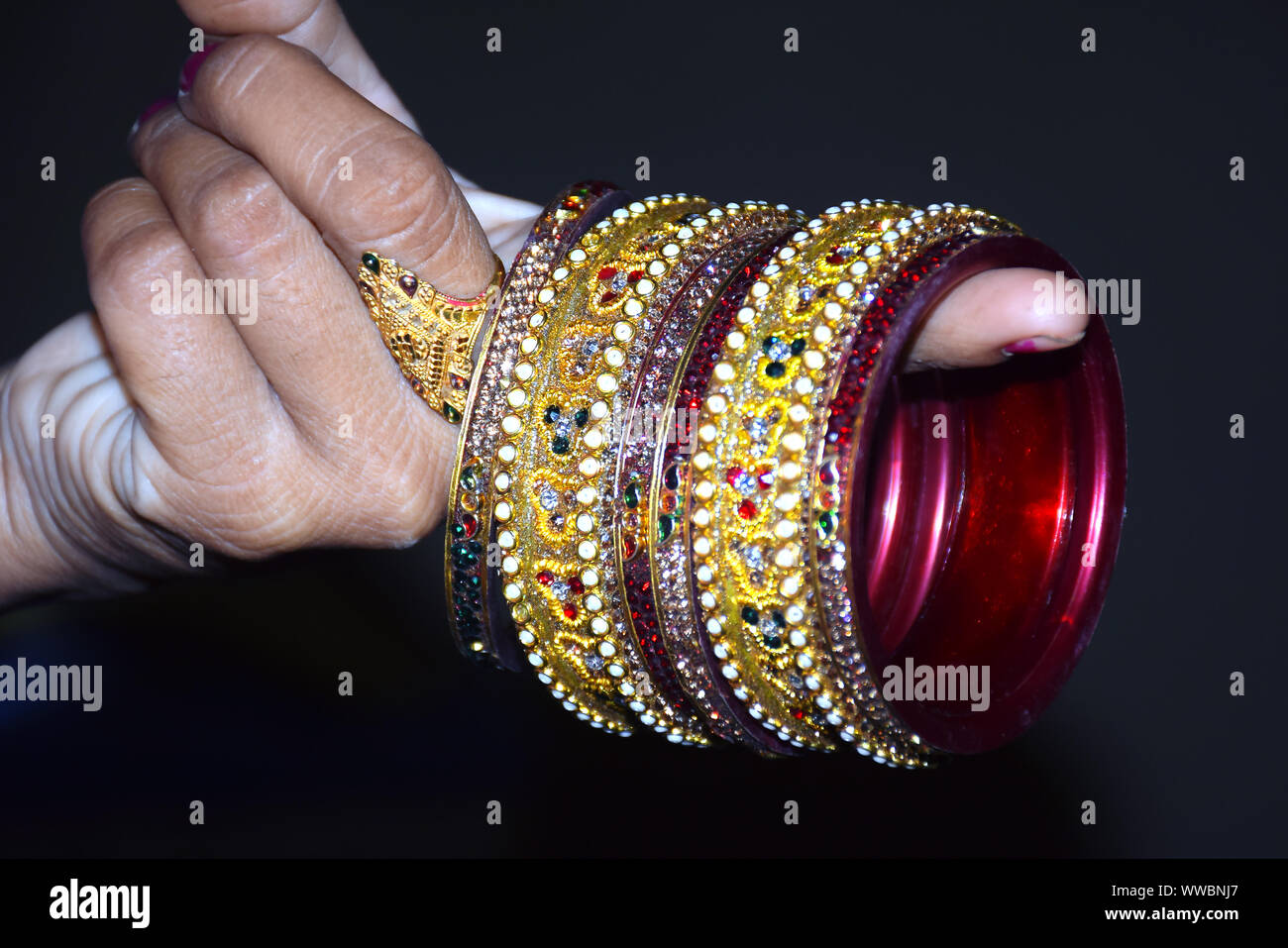 indian woman's hand holding bangle's with black background, Stock Photo