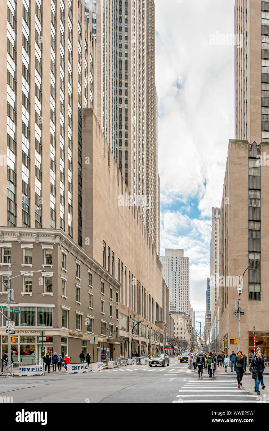 New York, NY, USA - December, 25th, 2018 - People crossing the streets of Manhattan, at Sixth Avenue with 49th West, near Magnolia Bakery. Stock Photo