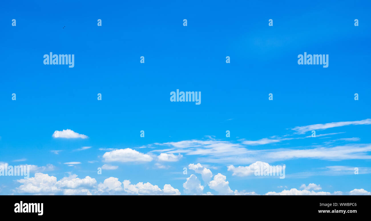 Beautiful blue sky and white cumulus clouds abstract background. Cloudscape background. Blue sky and fluffy white clouds on sunny day. Nature weather. Stock Photo