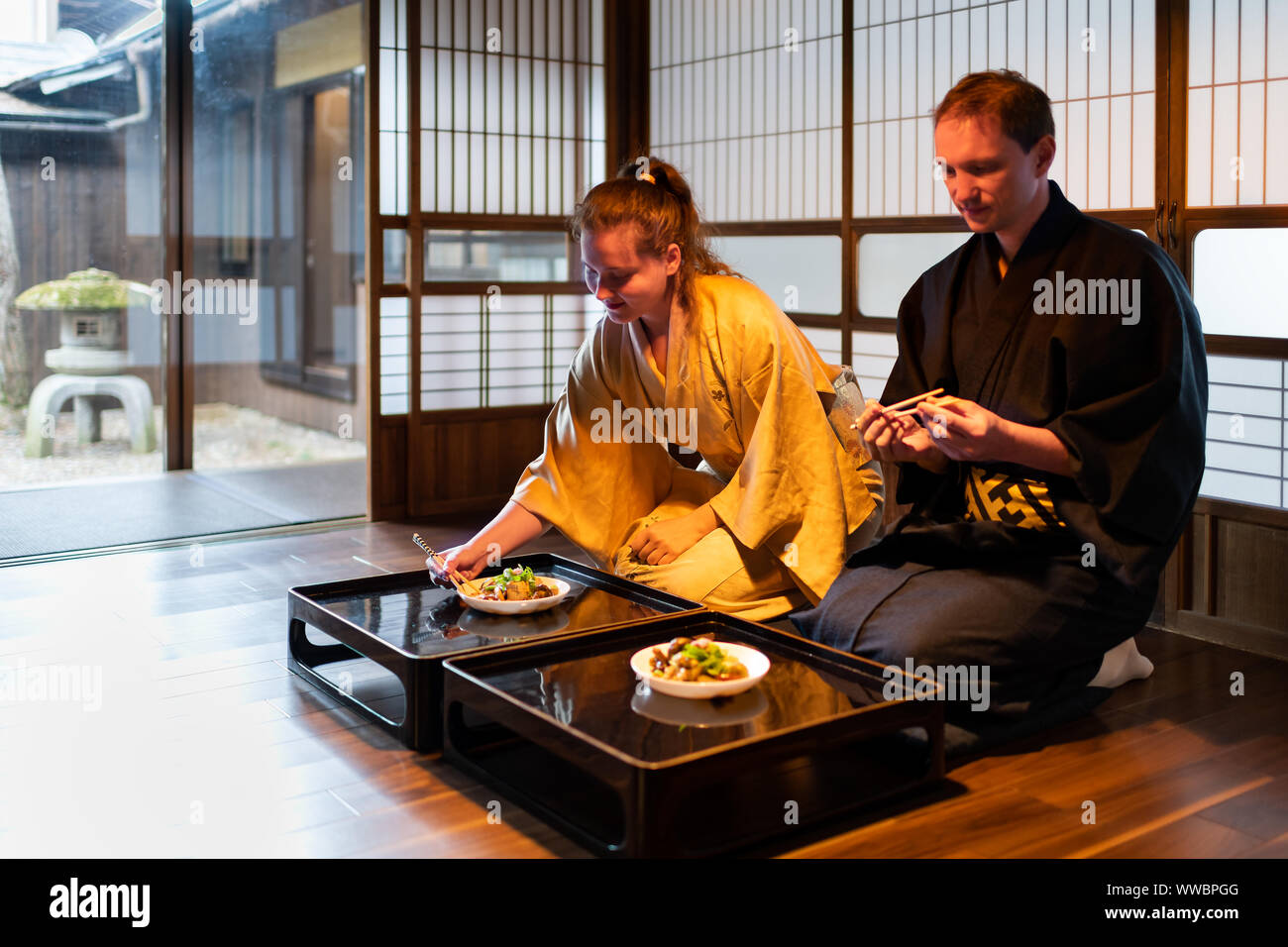 Couple In Kimono Seiza Sitting Holding Chopsticks Eating Food At Traditional Japanese Home Ryokan Room By Table Plates By Shoji Sliding Paper Doors Stock Photo Alamy