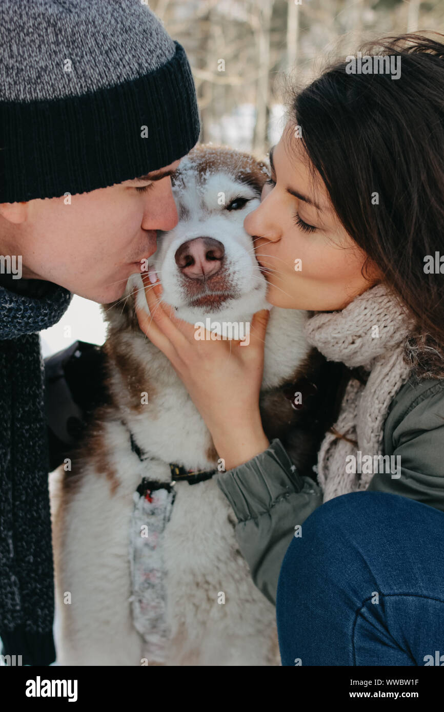 The happy couple with dog haski at forest nature park in the cold ...