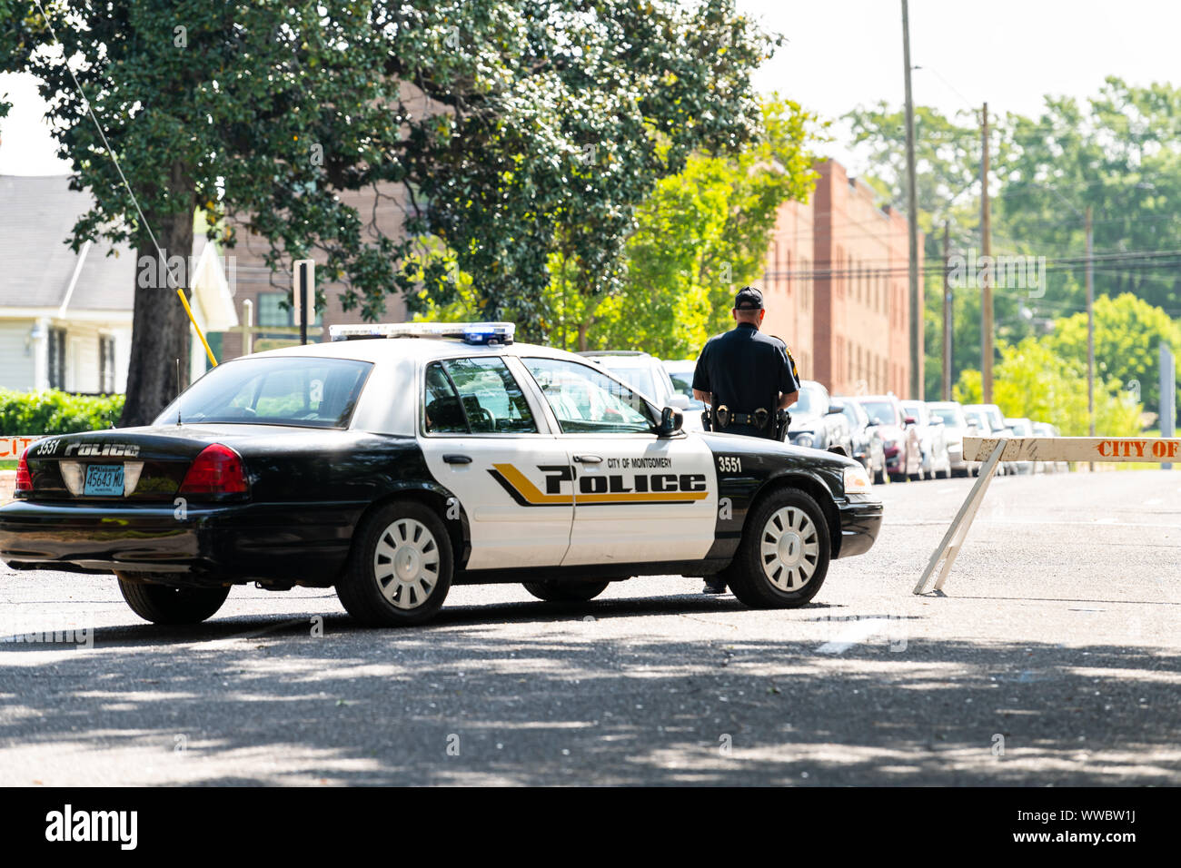 Montgomery, USA - April 21, 2018: Alabama city police officer car on street, with sign, people walking on sidewalk, blocked road block or roadblock Stock Photo