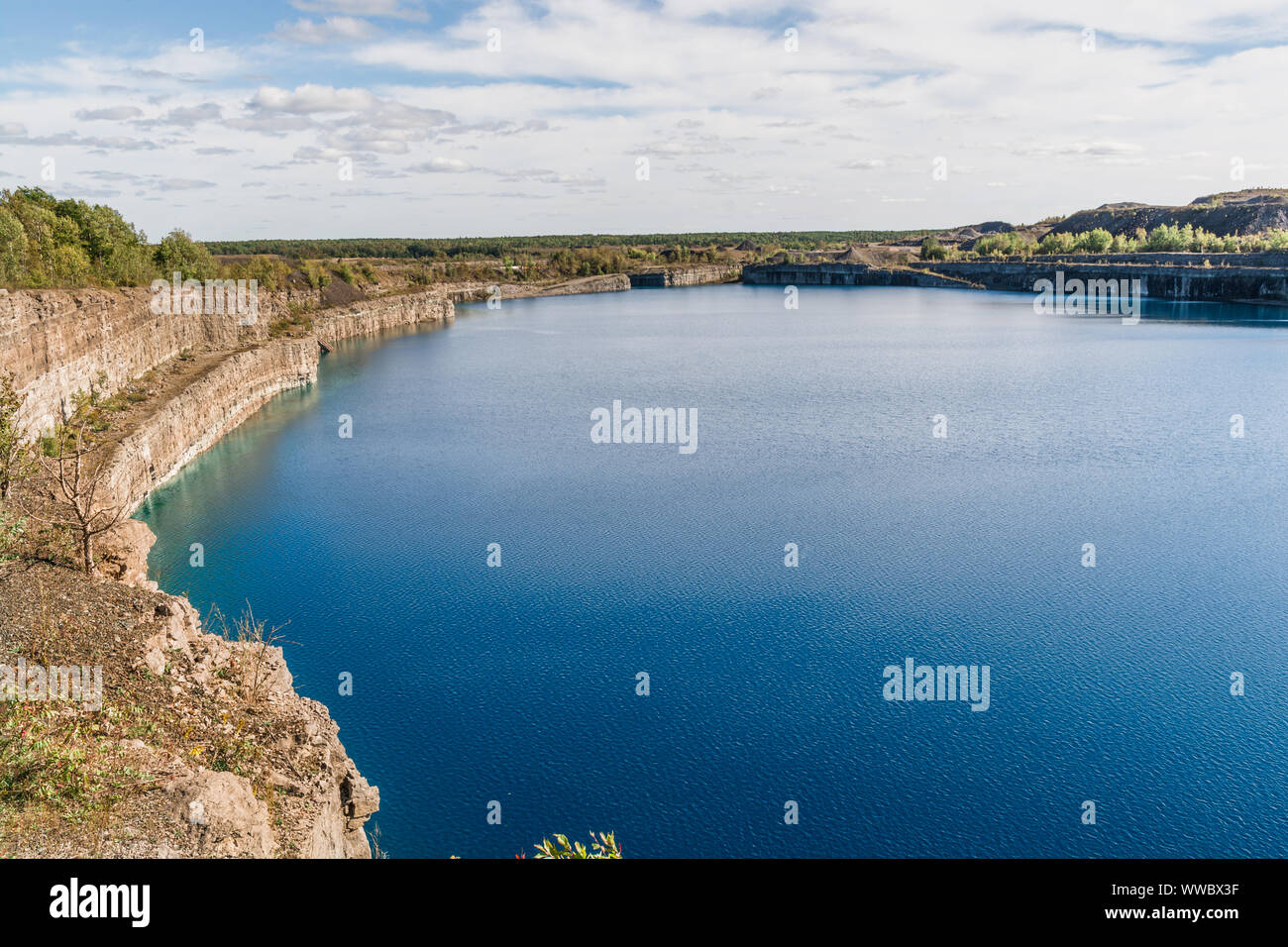 Marmora mine in Marmora Ontario Canada showing blue hole crater filled with water and beautiful rock strata on a sunny summer day Stock Photo
