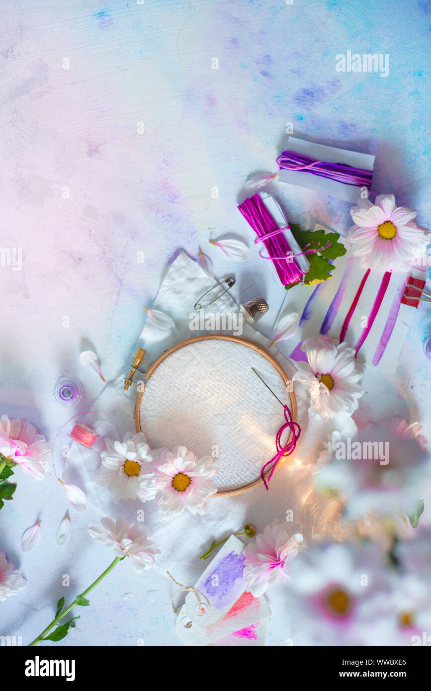Embroidery frame flat lay with flowers. Pink, white and purple pastel tones, copy space Stock Photo