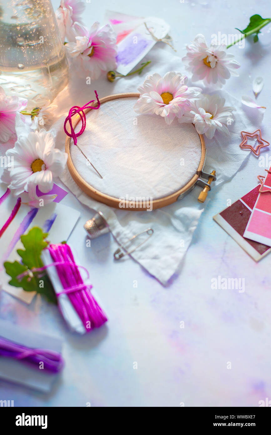 Pink, white and purple pastel tones embroidery frame close-up with flowers. Stock Photo