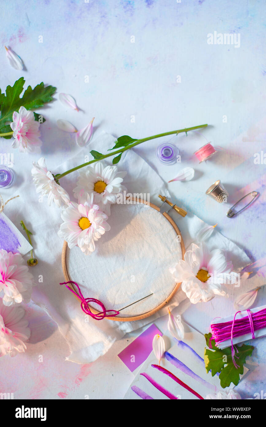 Embroidery frame flat lay with flowers. Pink, white and purple pastel tones, copy space Stock Photo