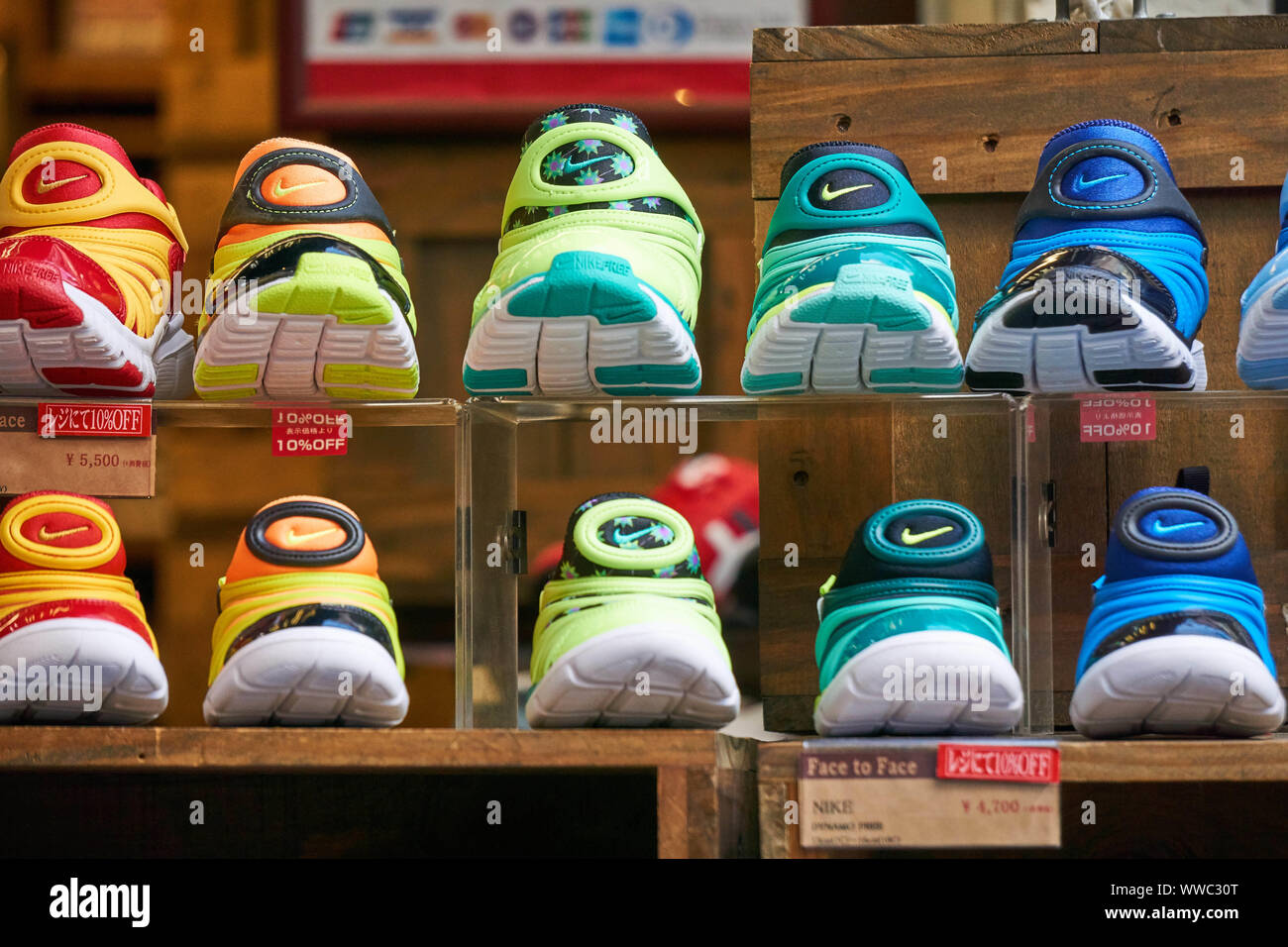 A variety of brightly colored Nike shoes are on display in rainbow order at a shop in Ameya Yokocho in Ueno, Tokyo, Japan. Stock Photo