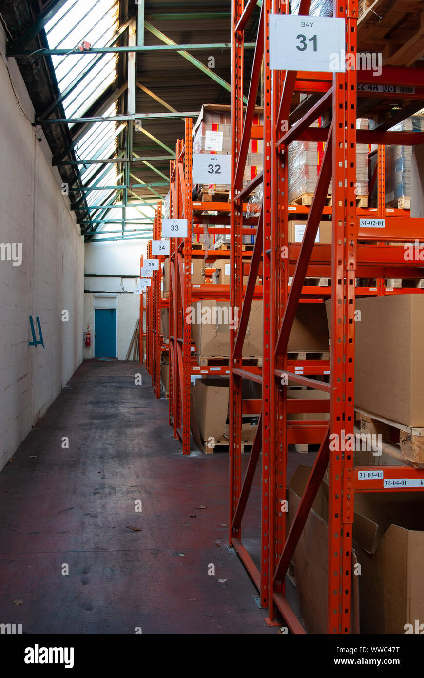 Warehouse racking at the side of a gangway with pallet boxes stored on ...