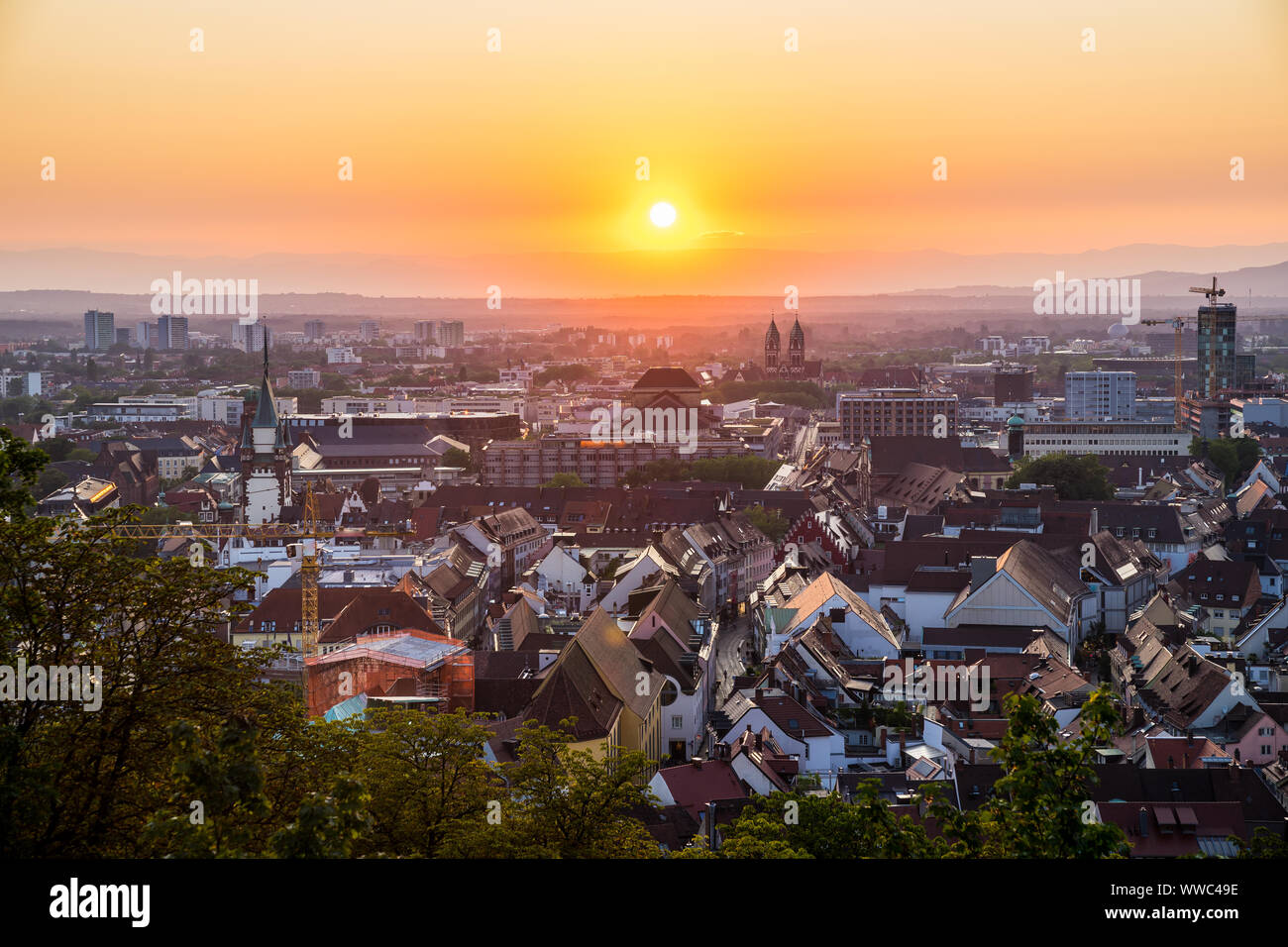 Germany, Romantic orange sunset sky over beautiful city freiburg im breisgau in black forest holiday region Stock Photo