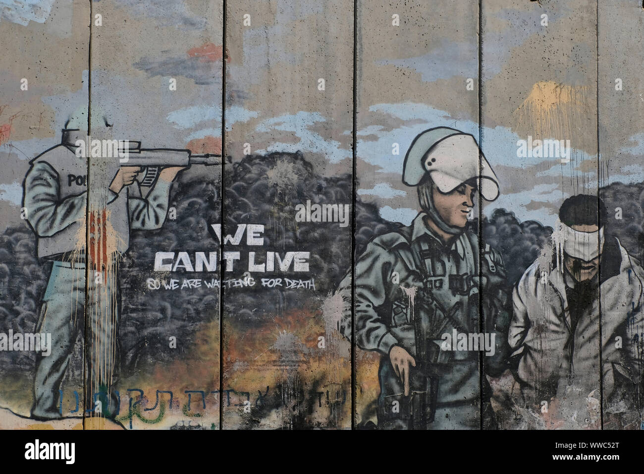A large graffito shows Israeli soldiers arresting a blindfolded Palestinian man carries the message: 'We can't live, so we are waiting for death.' painted on the separation barrier or wall in Aida also spelled 'Ayda, a Palestinian refugee camp situated 2 kilometers north of Bethlehem in the central West Bank established in 1950 by refugees from the Jerusalem and Hebron areas. Palestinian Territories, Israel Stock Photo