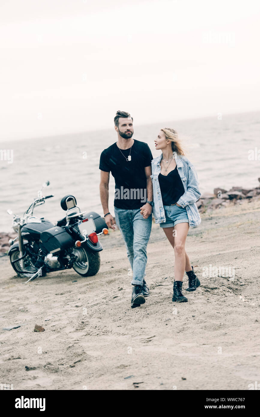 motorcycle couple holding hands