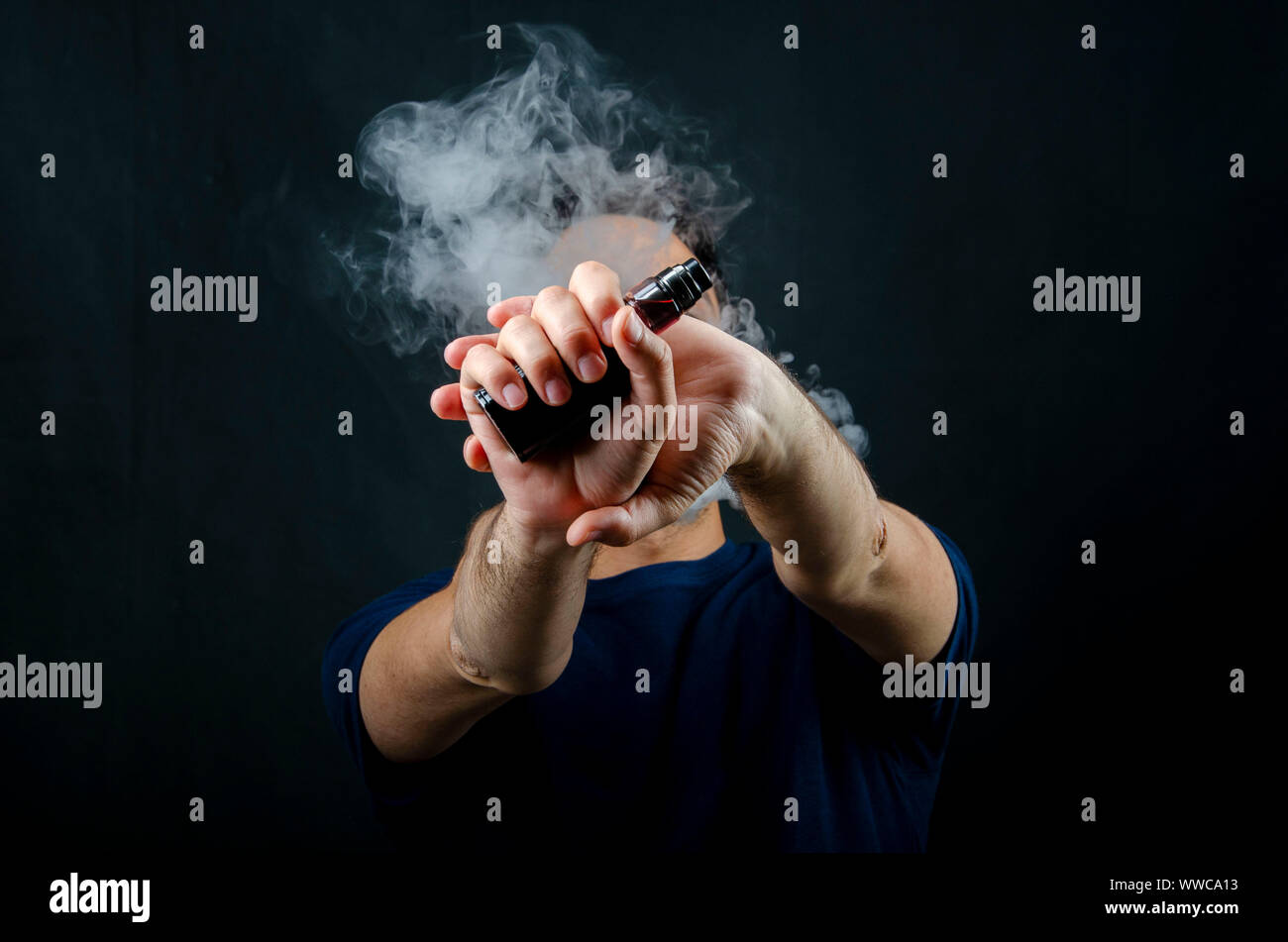 hand holding vape e-cigarette or electronic cigarette with white smoke over  a black background Stock Photo - Alamy