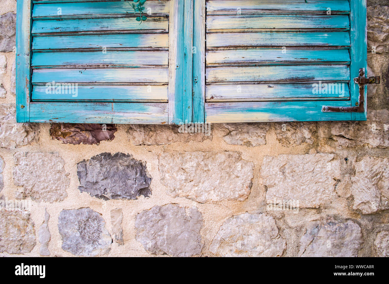 Old stone wall with closed weathered wooden shutters window Stock Photo ...