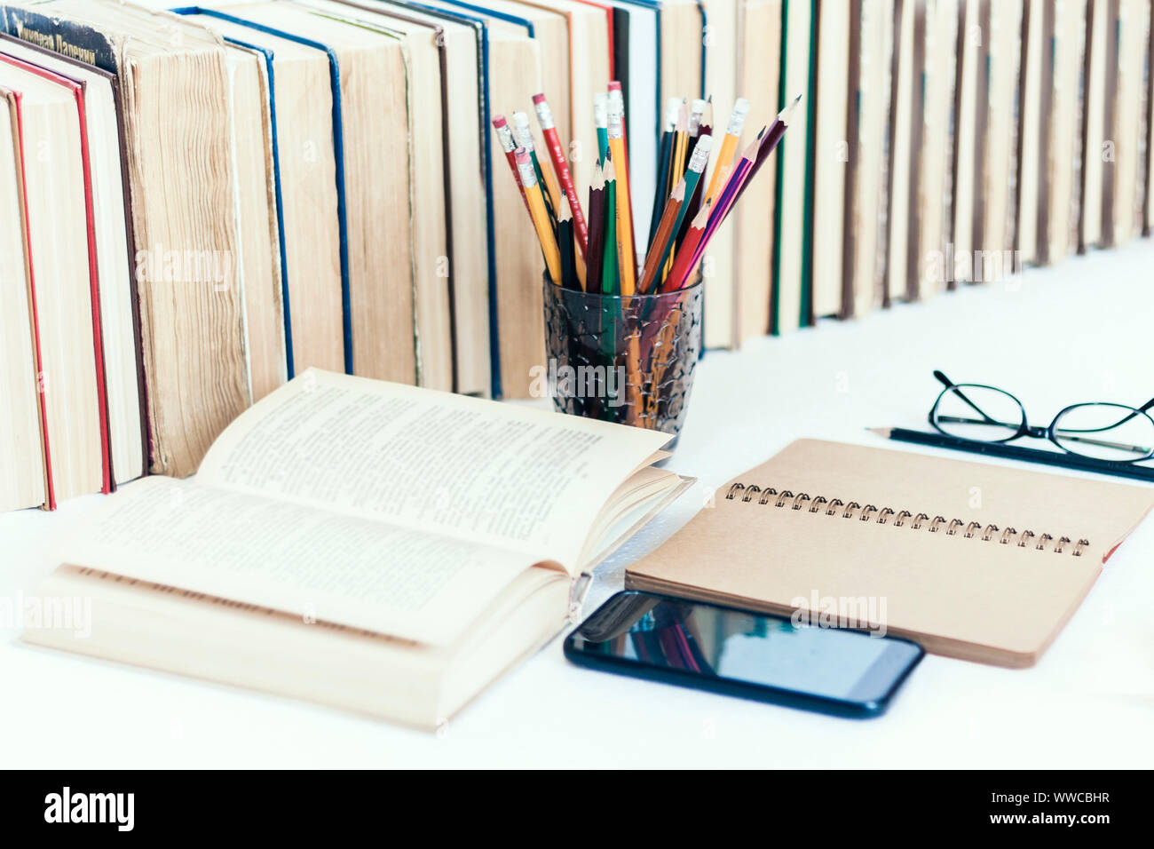 Open textbook, notebook, smartphone, stack of books education back to ...
