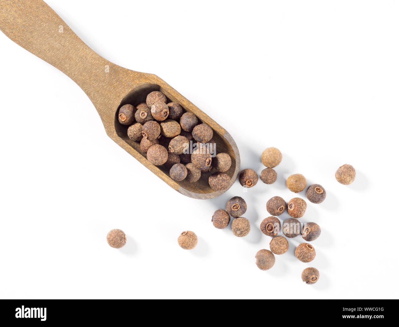 Allspice (Jamaica pepper) in wooden scoop diagonally on white