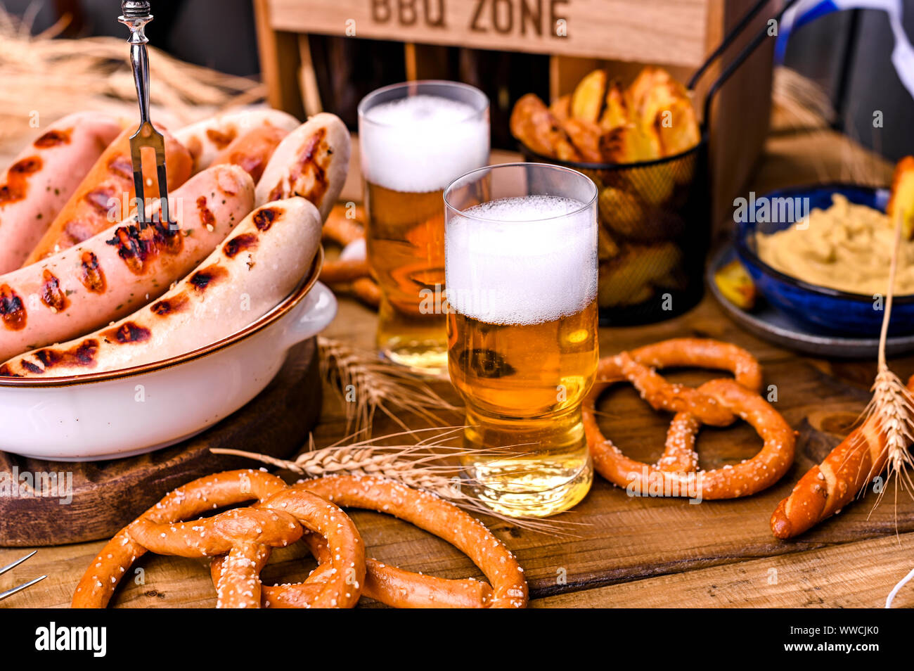 Fresh craft beer. German sausages on the grill. Traditional German sausages  and pastry brezel for a beer festival. Wood background and decor Stock  Photo - Alamy