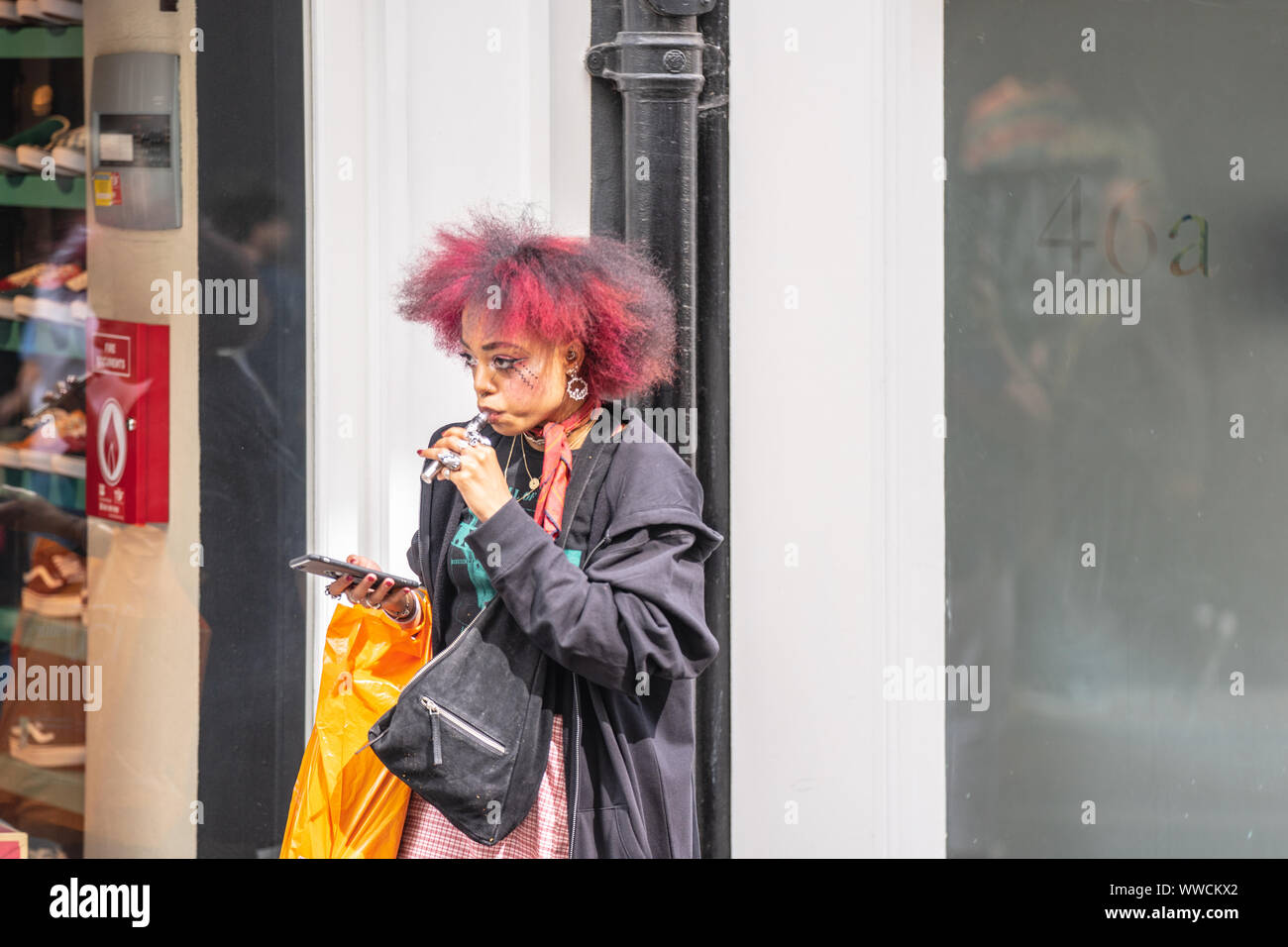 London, UK, July 14, 2019. Woman Vaping An electronic cigarette or e-cigarette, is a handheld battery-powered vaporizer Stock Photo