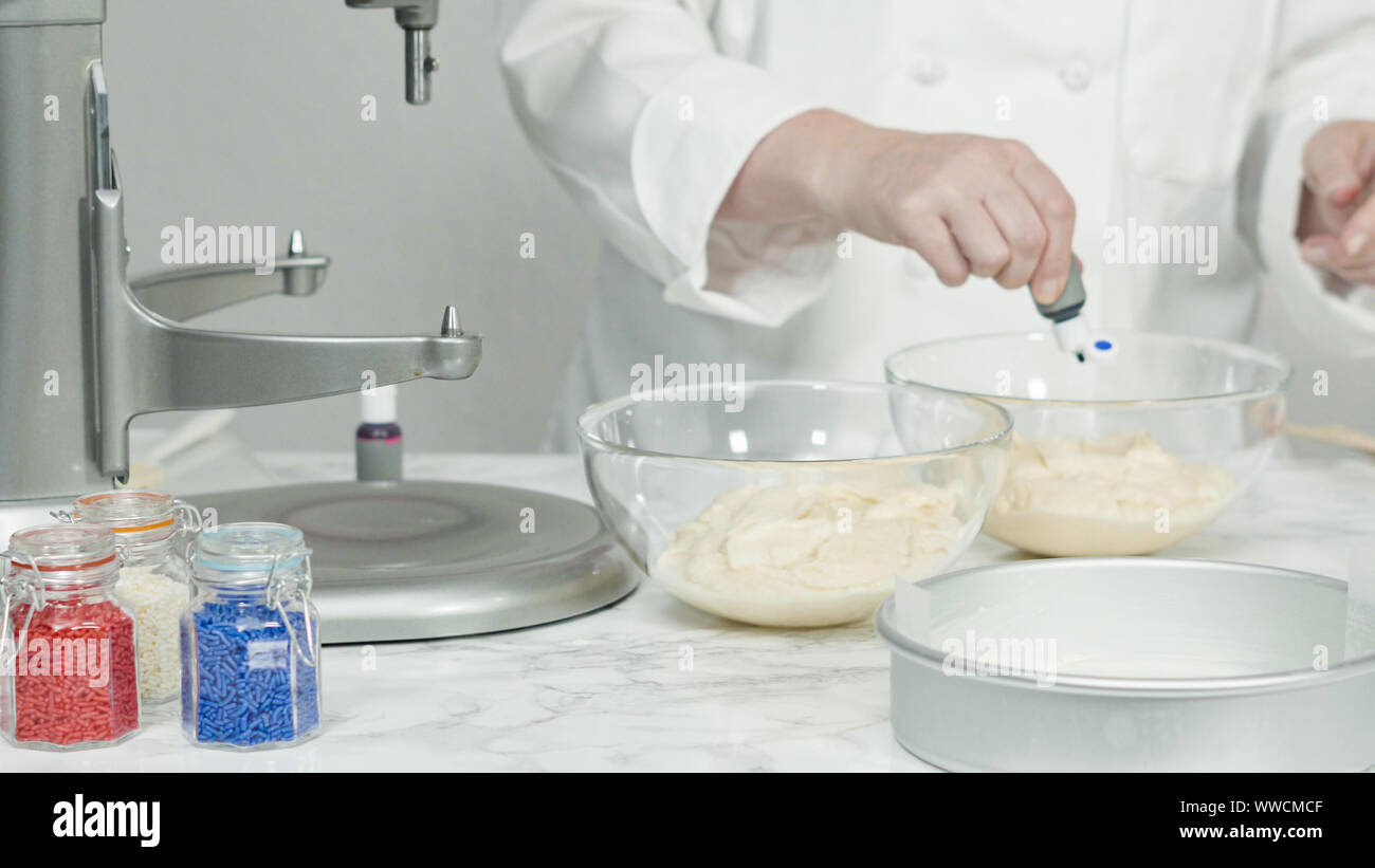 Step by step. Mixing food coloring into a cake batter to bake a threelayer vanilla cake Stock