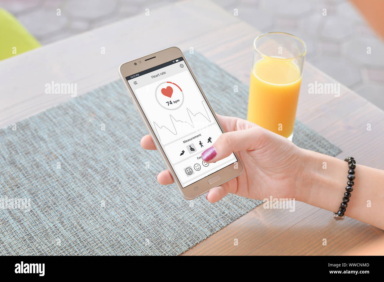 Concept of measuring heart rate app. Girl uses a sensor on mobile phone