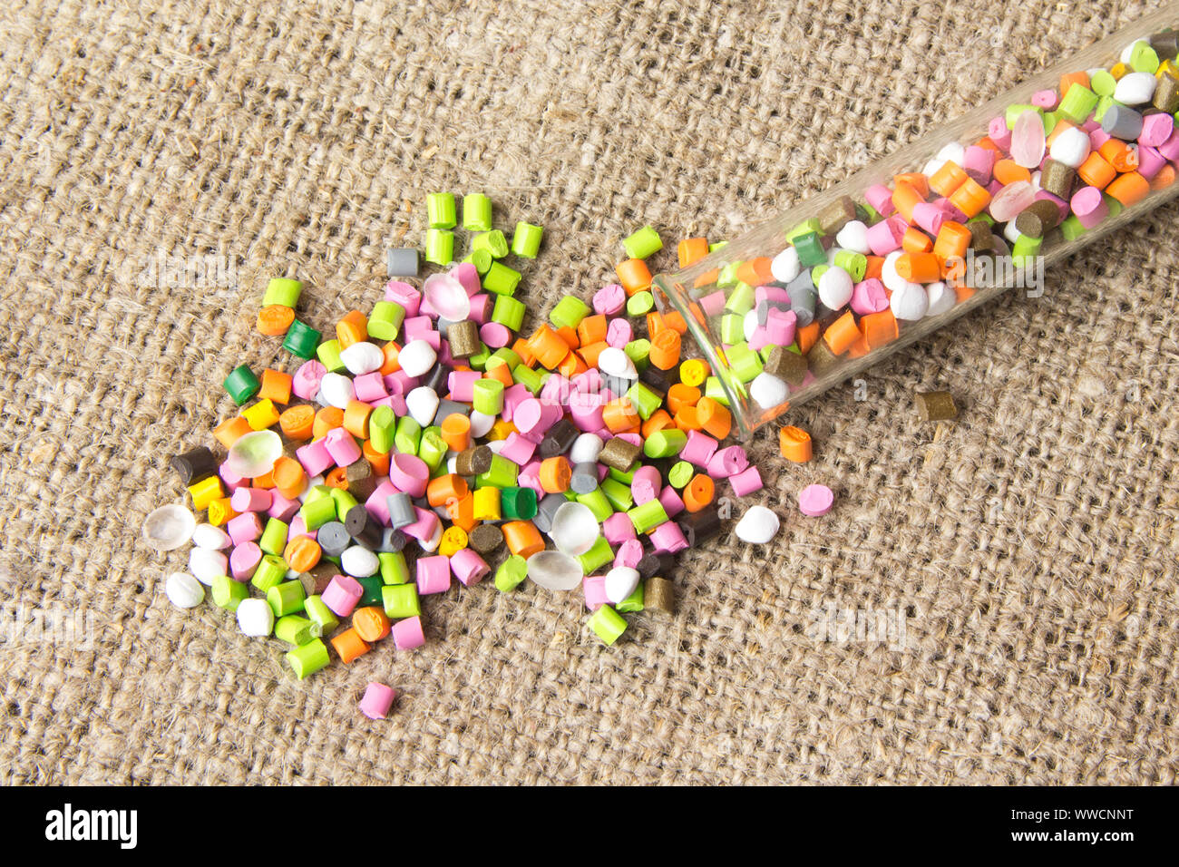 Plastic pellets .Polymeric dye in test tubes on gray background