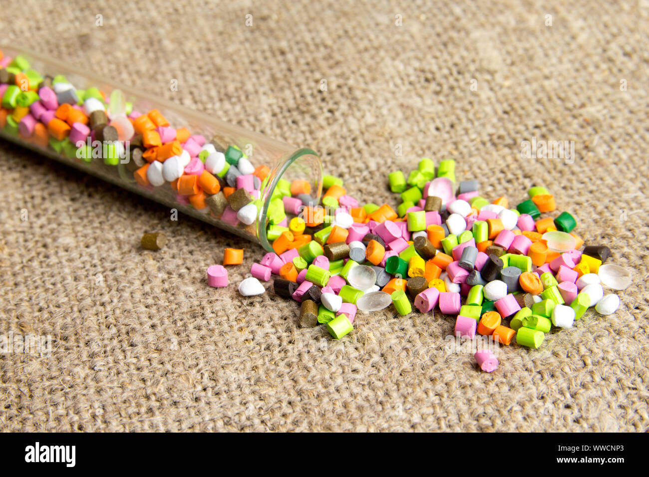 Plastic pellets .Polymeric dye in test tubes on gray background