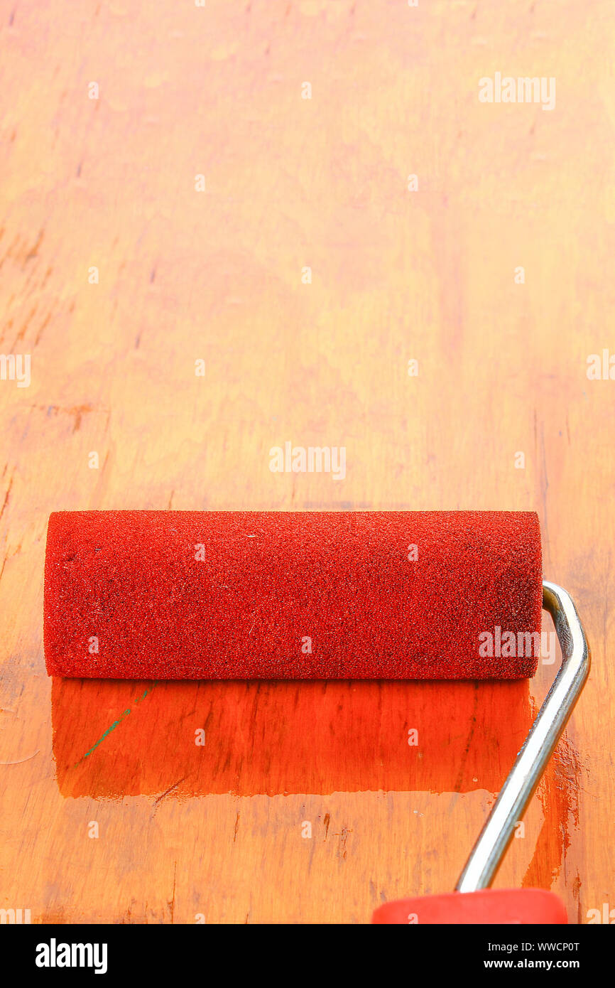 paint roll brush in white paint on plywood surface Stock Photo Alamy