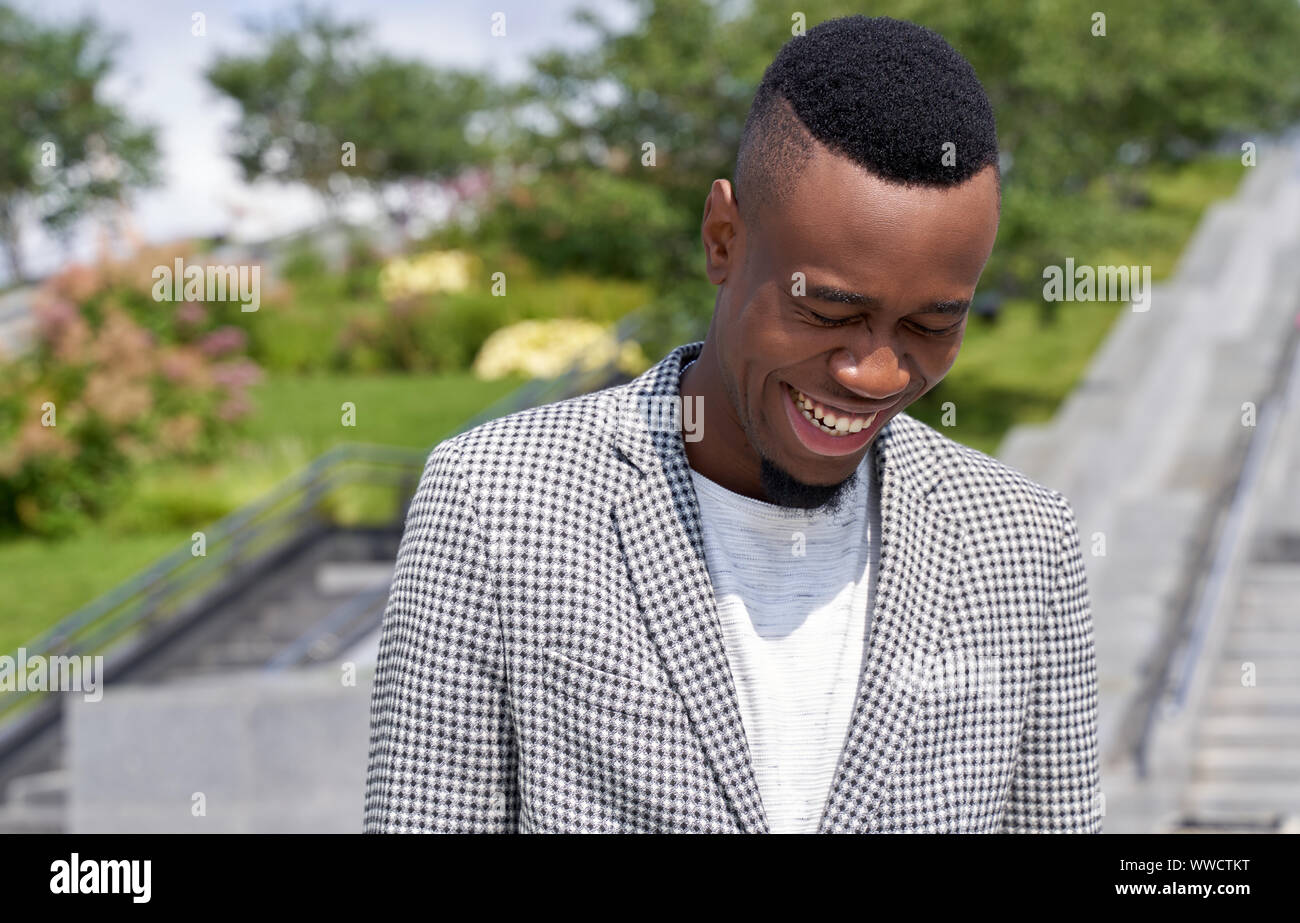 Cheerful Afro American looking down with laughter Stock Photo