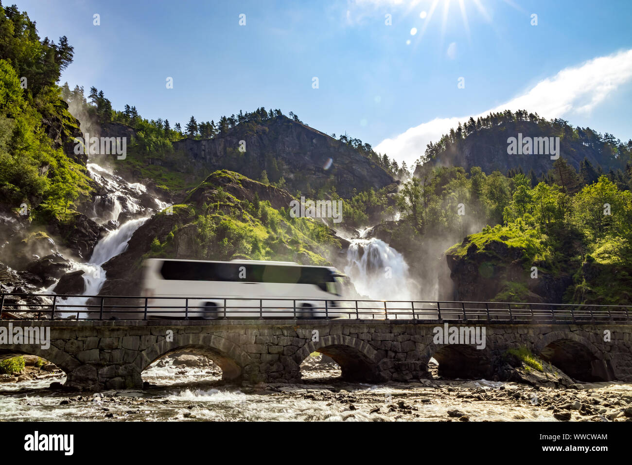 Tourist bus traveling on the road Latefossen Waterfall Odda Norway. Latefoss is a powerful, twin waterfall. Stock Photo