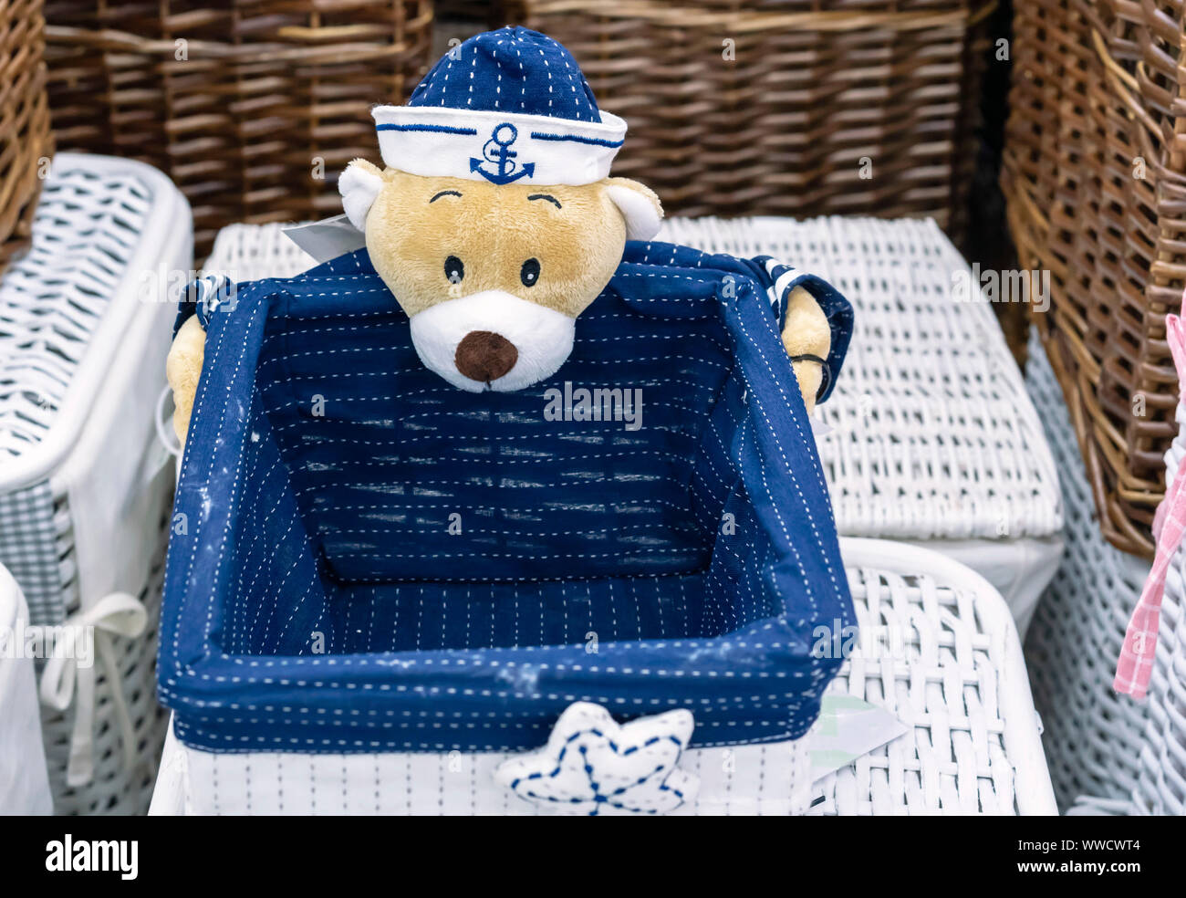 Wicker laundry basket with a teddy bear in marine uniform Stock Photo
