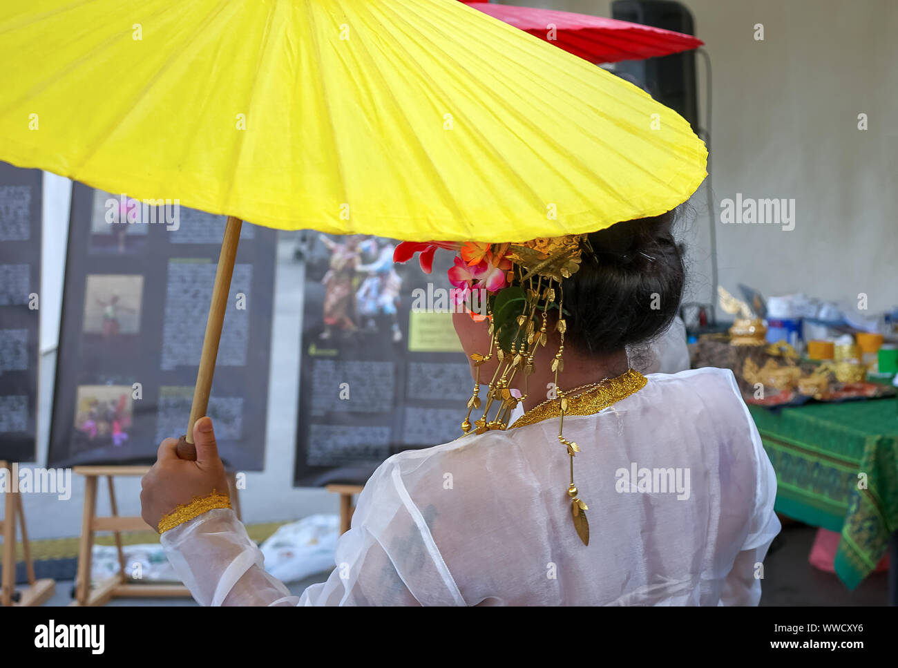 Woman in the national Thai costume with a yellow umbrella. Stock Photo