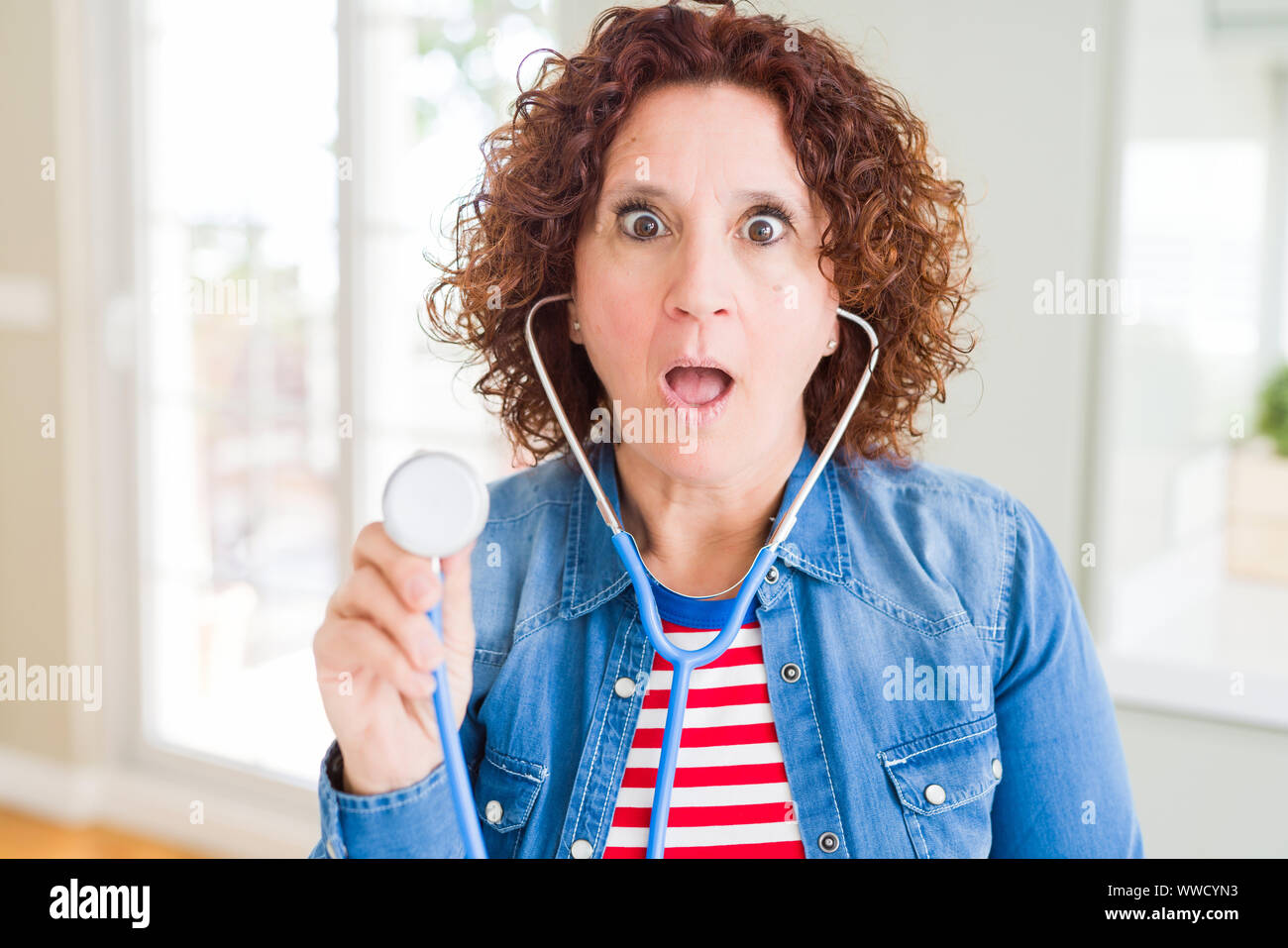 Senior Woman Checking Health Using Stethoscope Scared In Shock With A Surprise Face Afraid And 