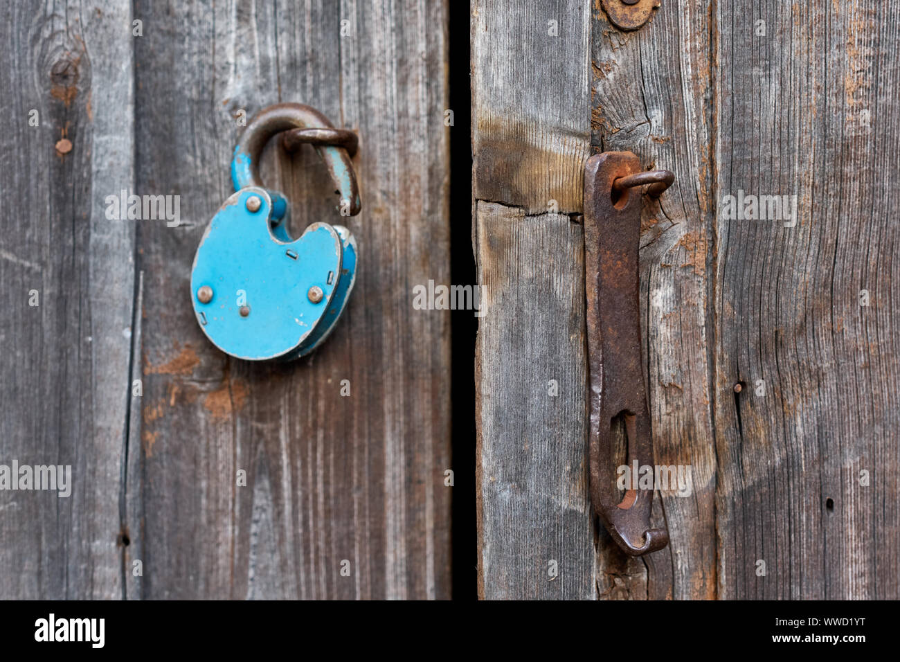 Blue old rusty unlocked padlock on wooden door Stock Photo - Alamy